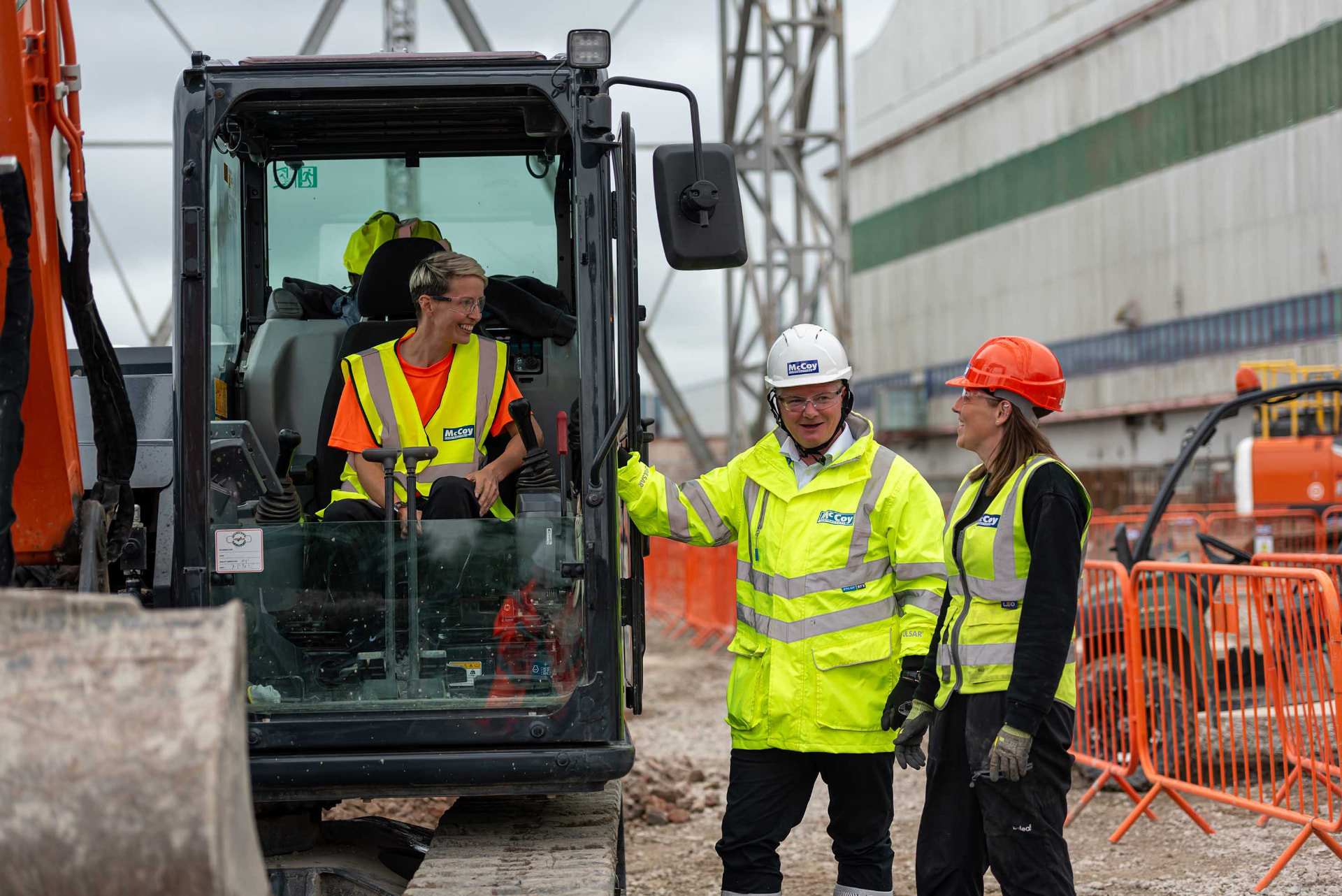 McCoy Contractors team on site beside an excavator during a project visit
