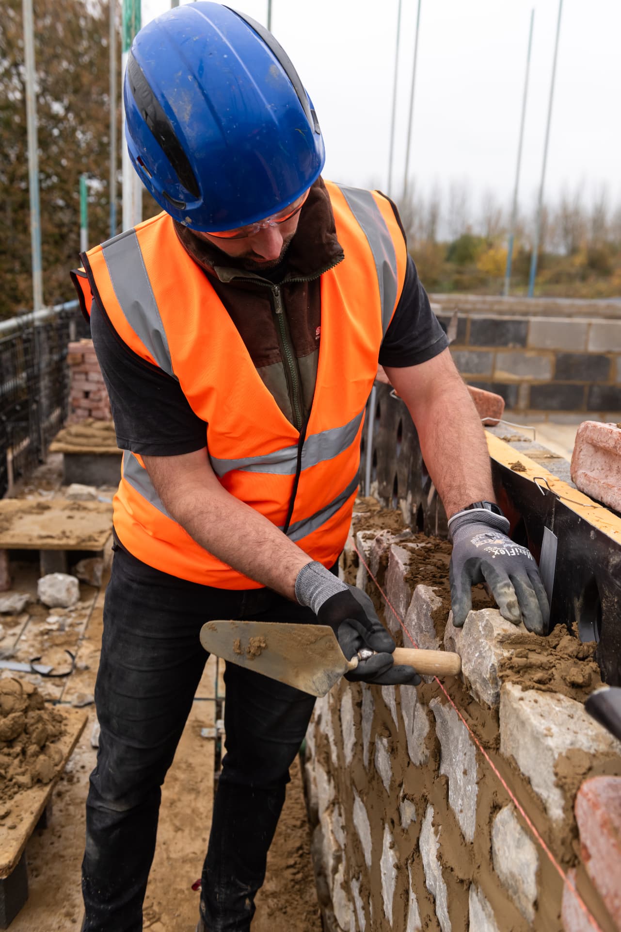 Bricklayer laying stone with Remix dry mortar on site