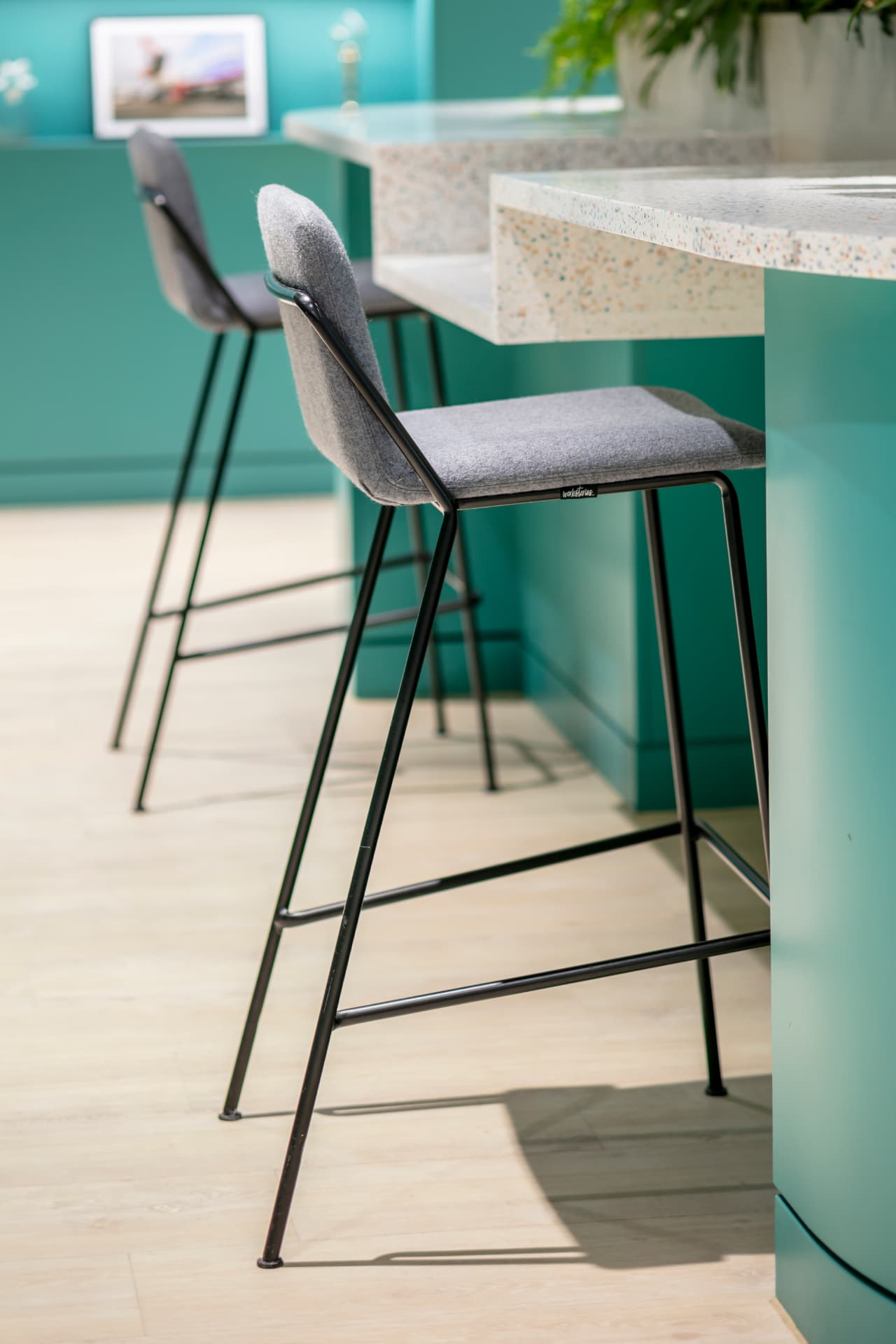 Bar stools and terrazzo counter in a teal breakout space