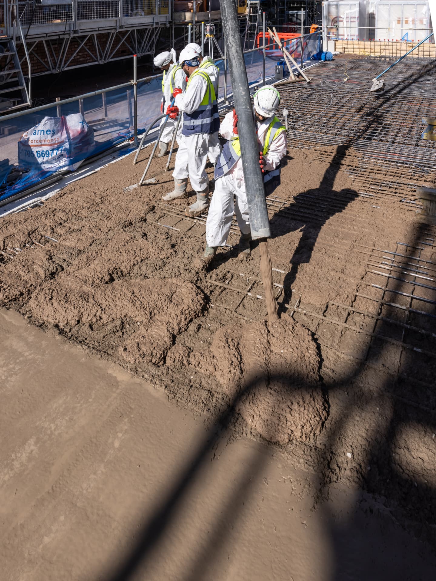 Concrete pour over reinforcement mesh on a London slab