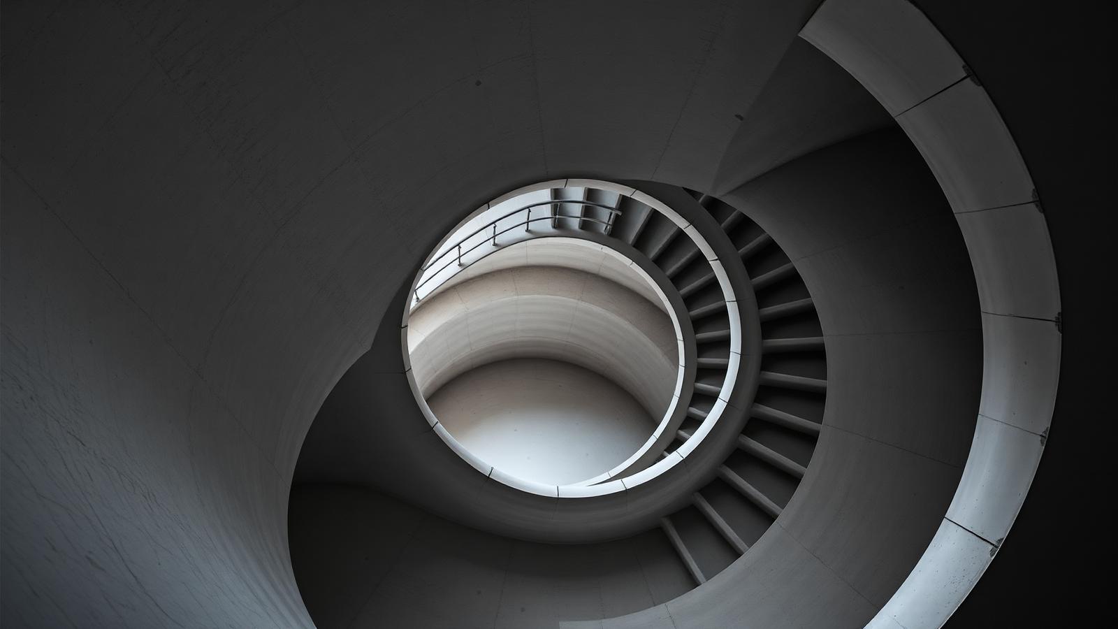 Sweeping concrete spiral staircase seen from below